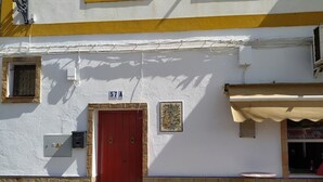 Un bâtiment avec une porte rouge, une petite fenêtre et le numéro « 57A » au-dessus de la porte.