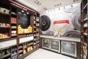 A snack and treat section with shelves stocked with various snacks, a chalkboard sign, and beverage dispensers.