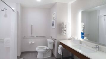 Un baño moderno con inodoro, lavamanos y ducha.