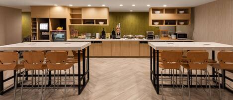 Una cocina moderna con armarios de madera, una isla central y taburetes de bar.