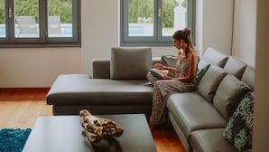 A modern living room with a sofa, a small table, and a large window. - Villa Laura (Gardone Riviera)