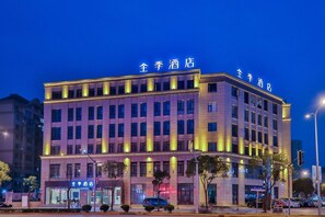 A hotel with multiple floors, illuminated signage, and a modern architectural design.