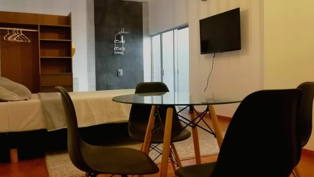 A modern room with a bed, a table with chairs, a TV, and a wardrobe. - Executive Studio - 15 min. from US Consulate | Flexible Check-in (Ciudad Juárez)