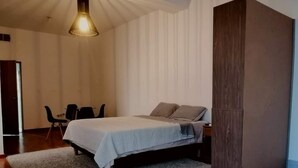 A bedroom with a bed, a desk, and a chair. - Executive Studio - 15 min. from US Consulate | Flexible Check-in (Ciudad Juárez)