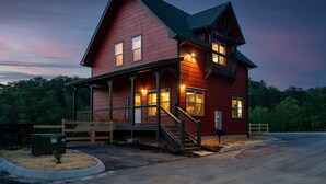A two-story red building with a porch, a staircase, and a 'Welcome' sign.