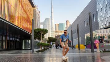 A modern urban street with a tall skyscraper in the background.