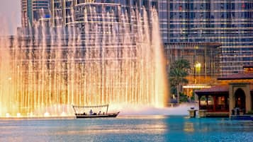 A boat in a body of water with a large fountain display in the background.