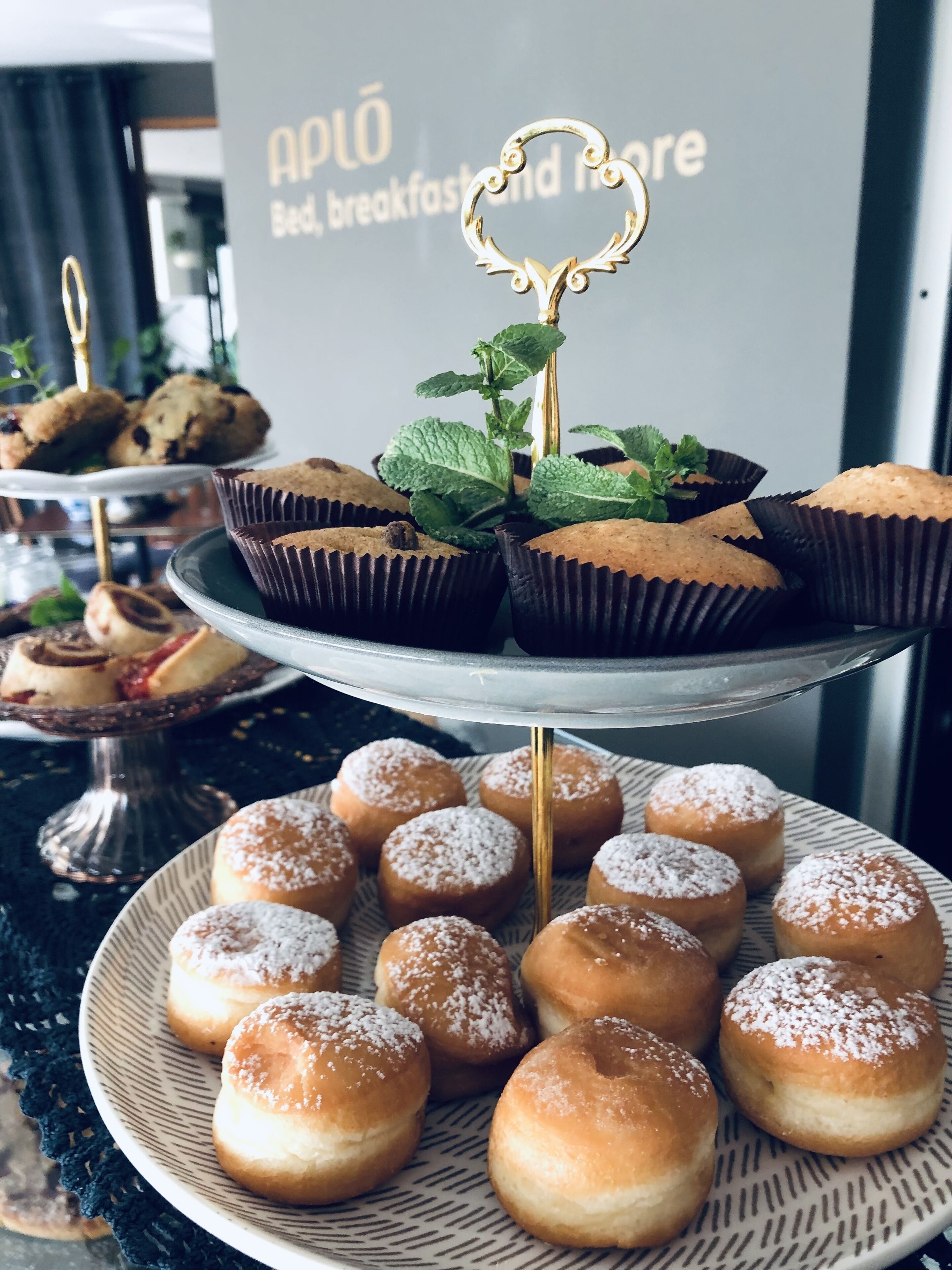 Un présentoir de desserts avec divers pâtisseries et une pancarte en arrière-plan.