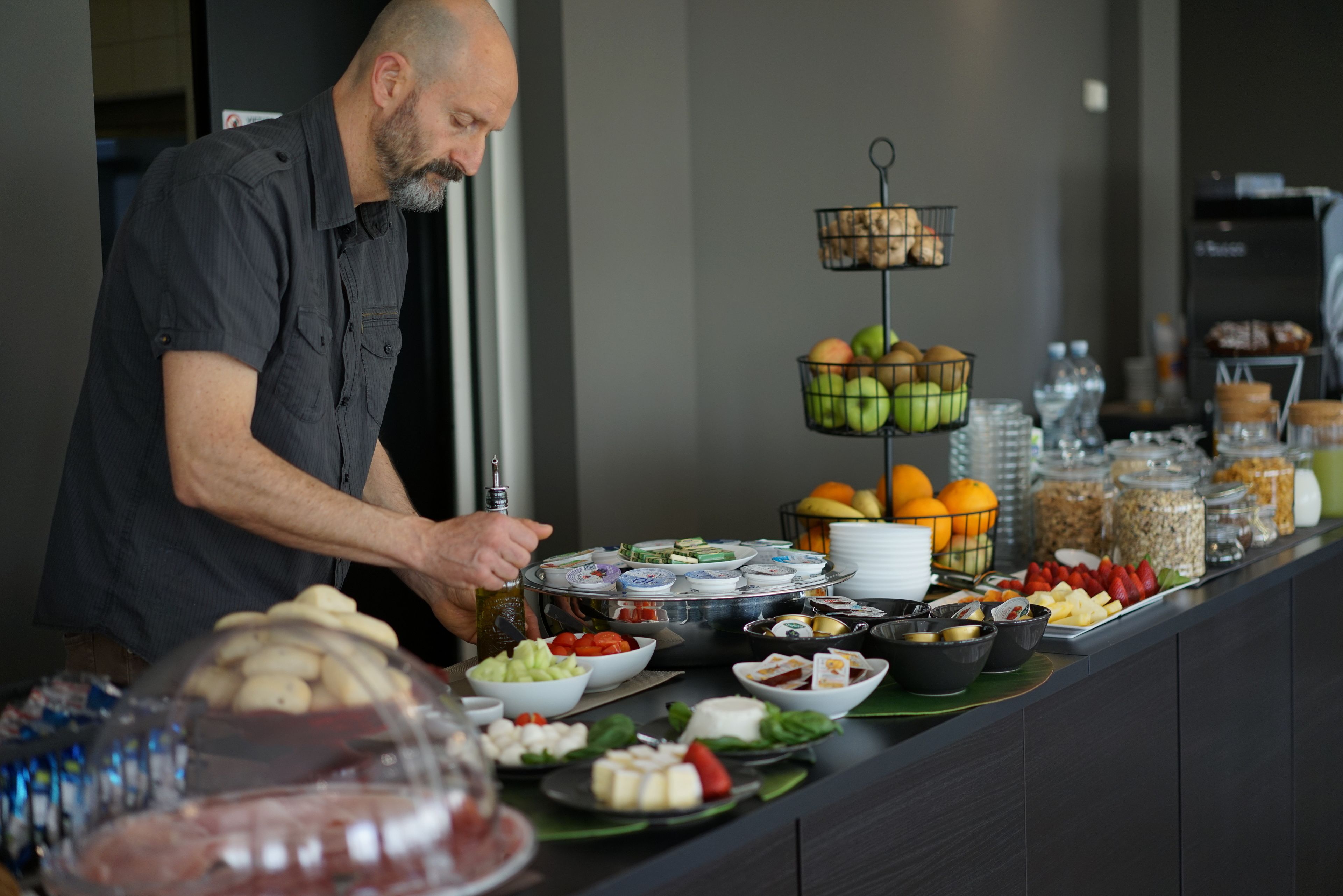 A buffet setup with various food items and a person serving.