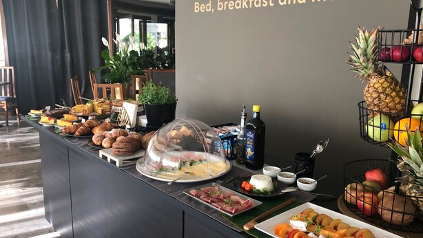 Un bufé de desayuno con diversos pasteles, frutas y bebidas.