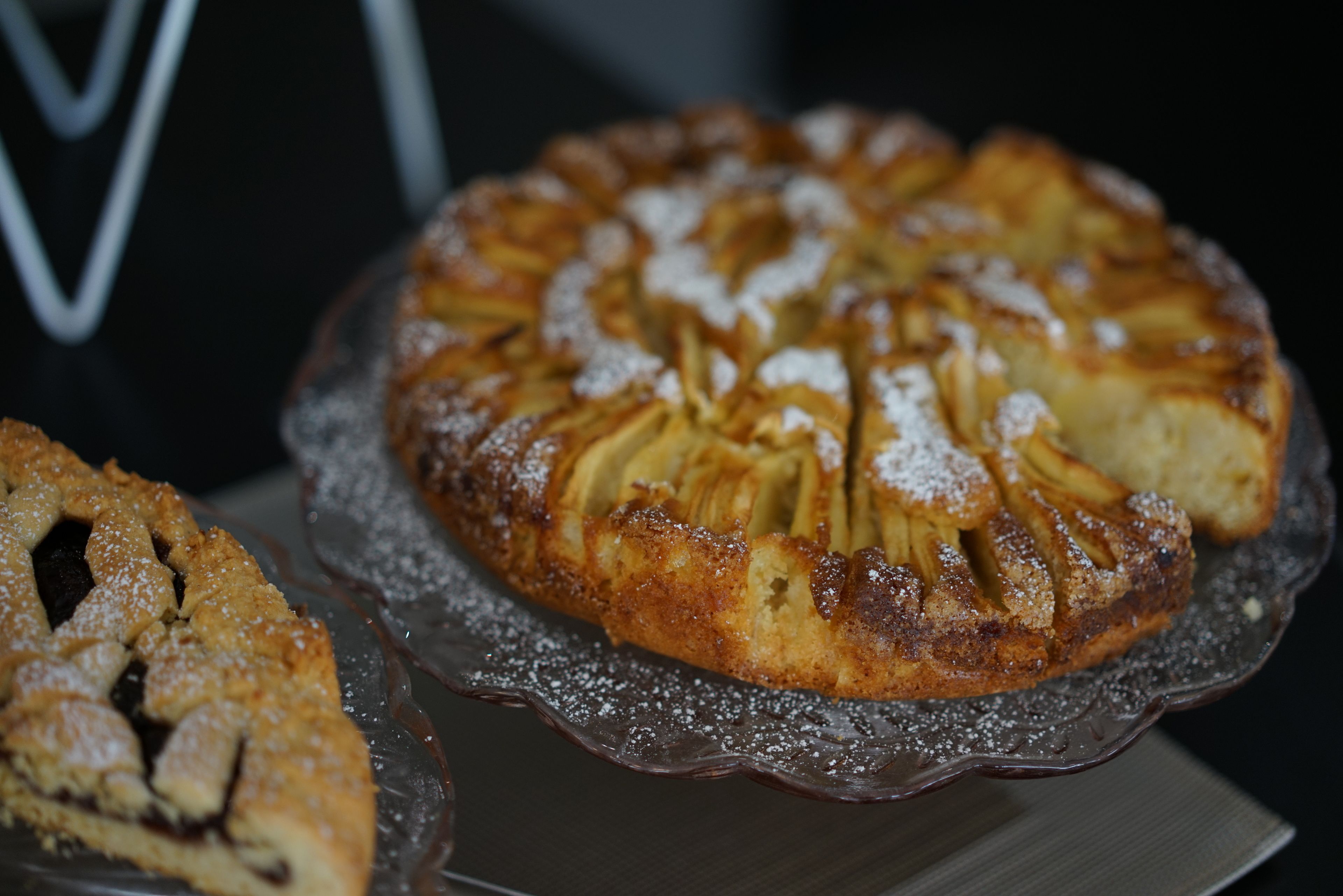Un pastel redondo con cobertura enrejada sobre un plato de vidrio.