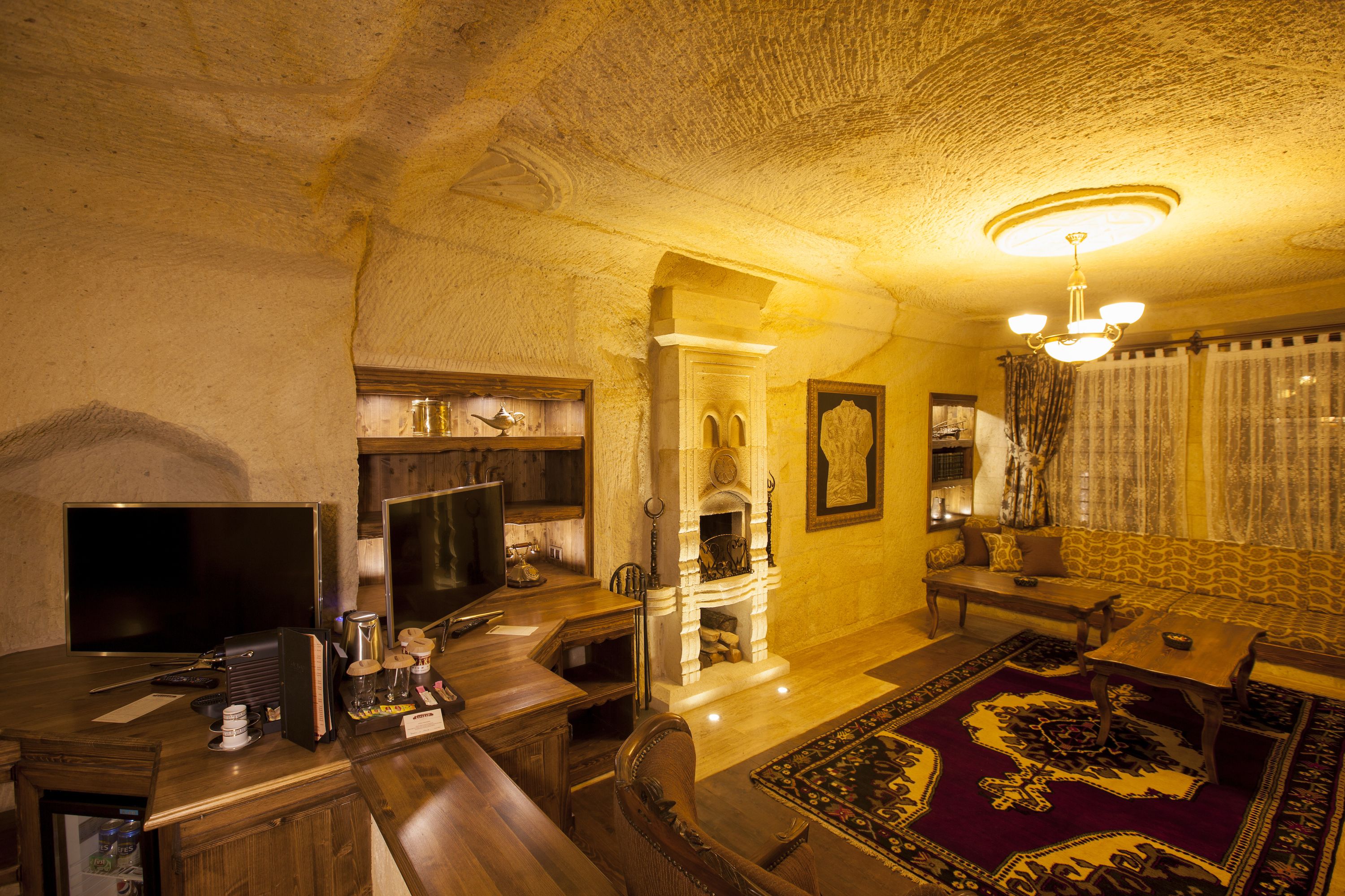 A cozy living room with a fireplace, a television, and a comfortable sofa.