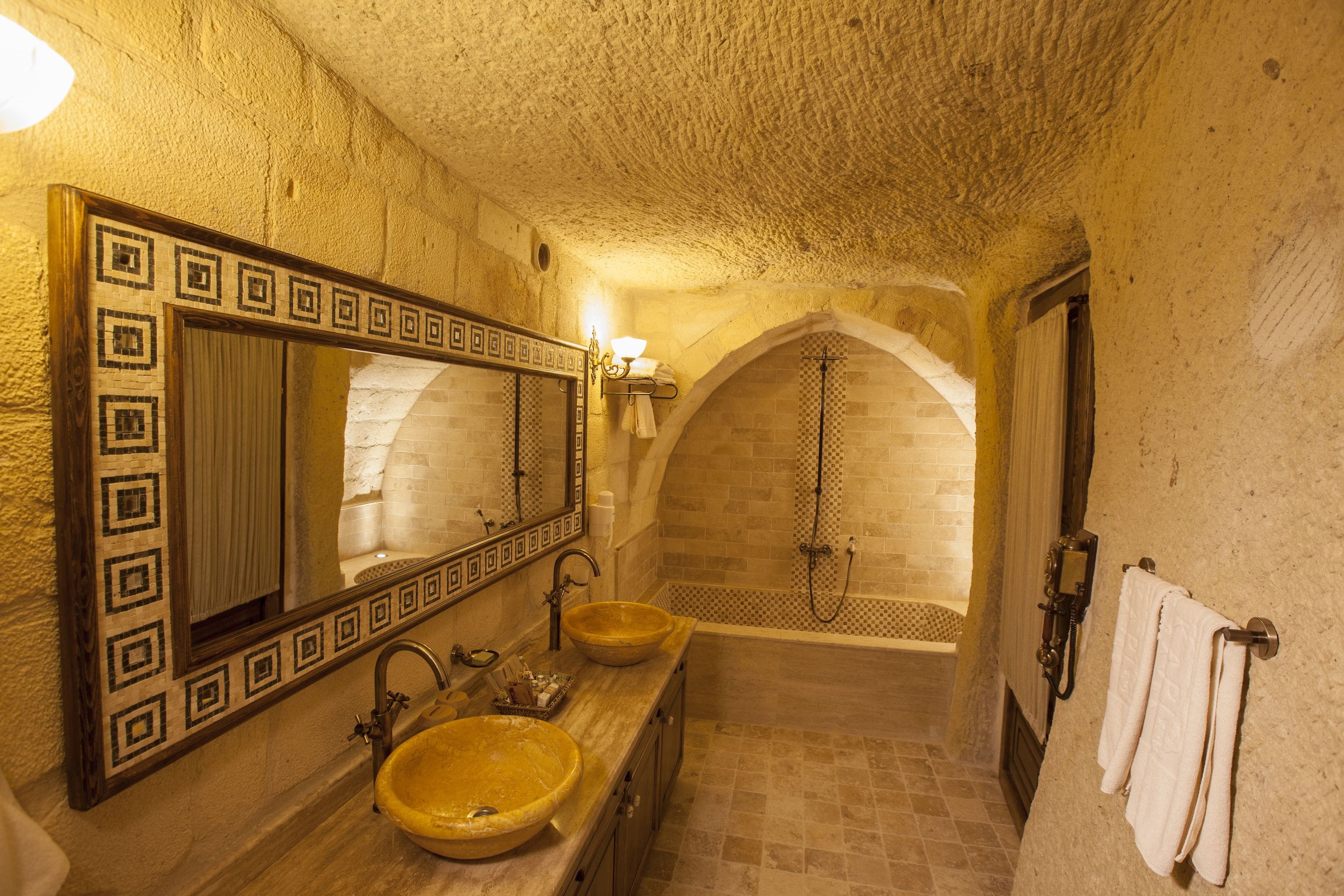 Ein Badezimmer mit einem großen Spiegel, zwei Waschbecken und einer Badewanne.