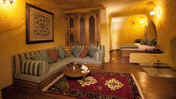 A cozy living room with a wooden sofa, a patterned rug, and a wooden coffee table.