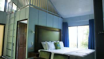 Un dormitorio con cama, escritorio y ventana con cortinas.