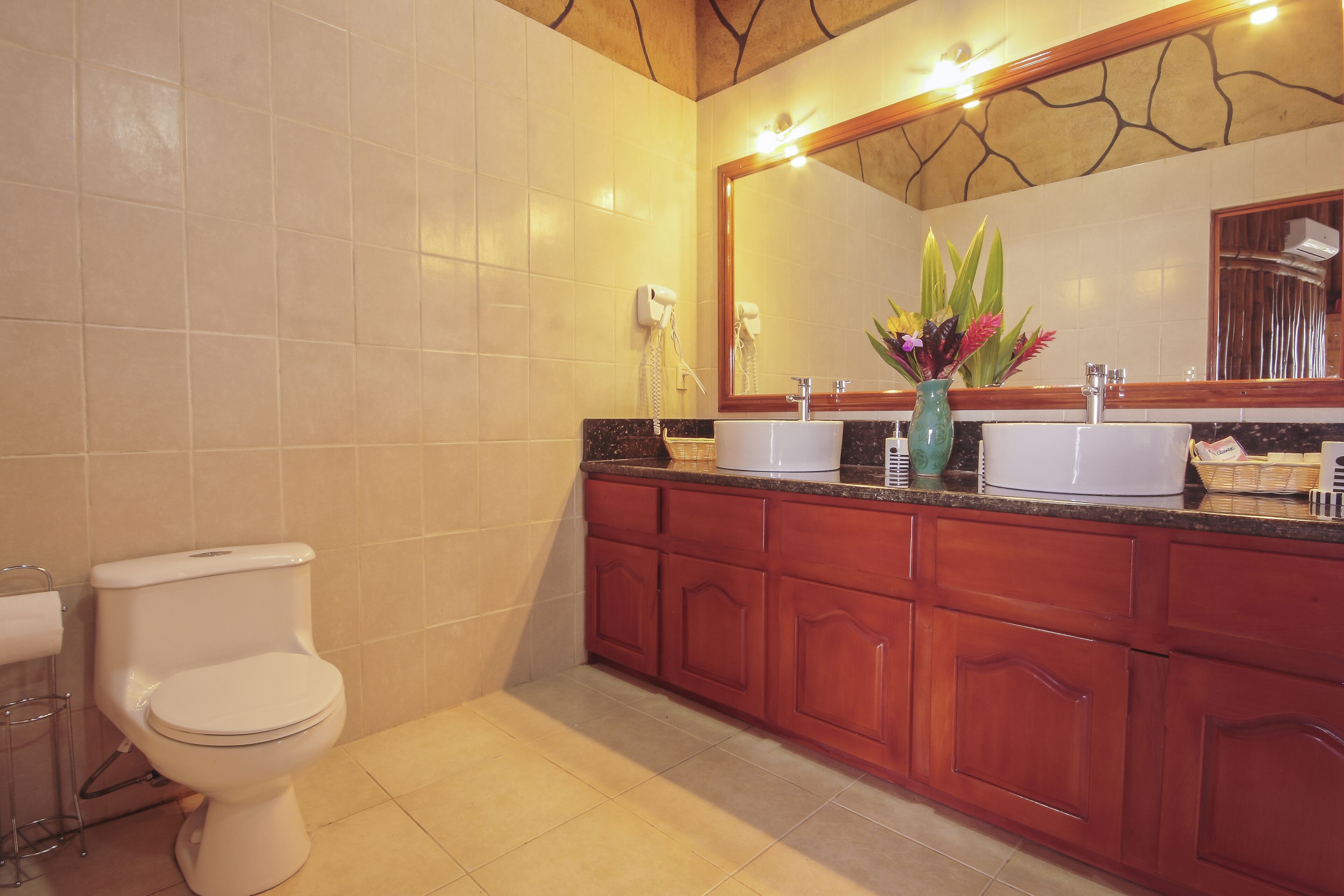 A bathroom with a toilet, a sink, and a vanity with cabinets.