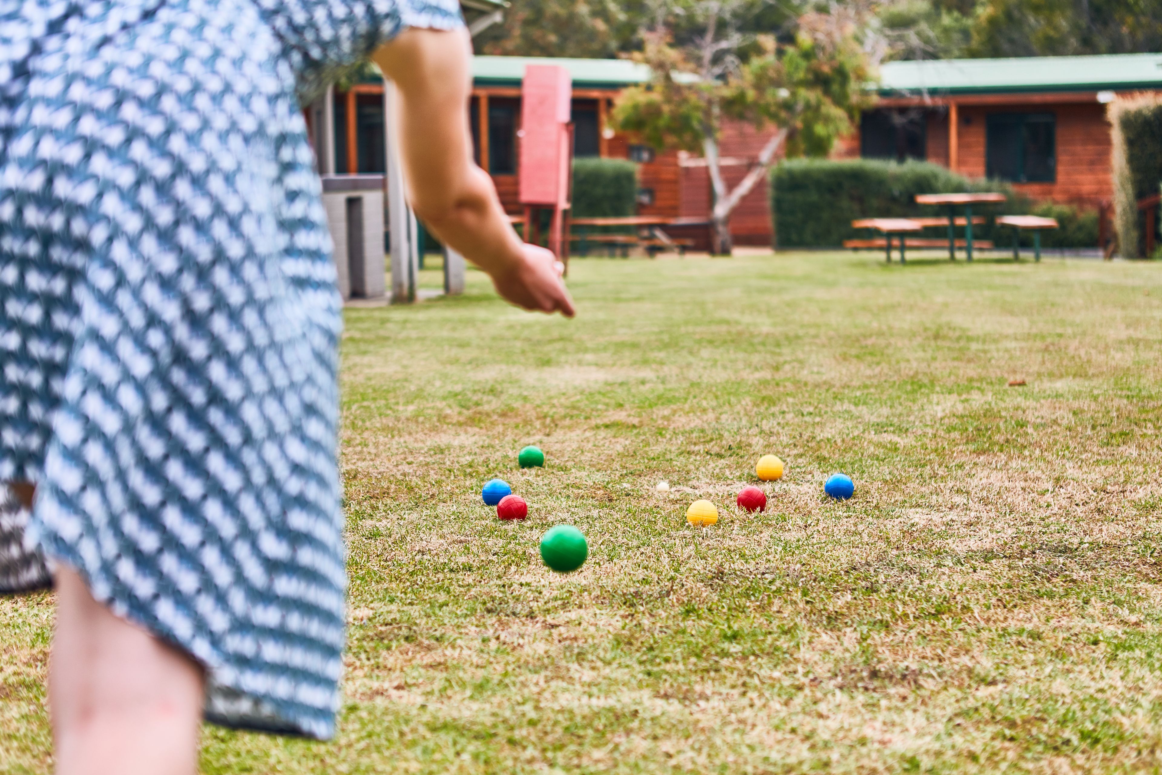 A grassy area with colorful balls scattered on the ground.