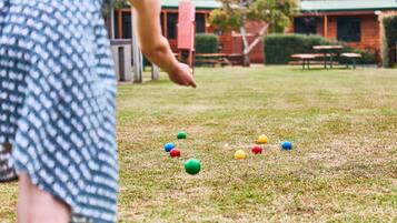 A grassy area with colorful balls scattered on the ground.