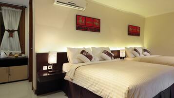 A hotel room with two beds, a nightstand, a lamp, a window with curtains, and wall art.