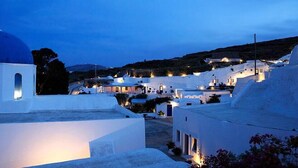 A coastal village with white-washed buildings and a prominent blue-domed church.