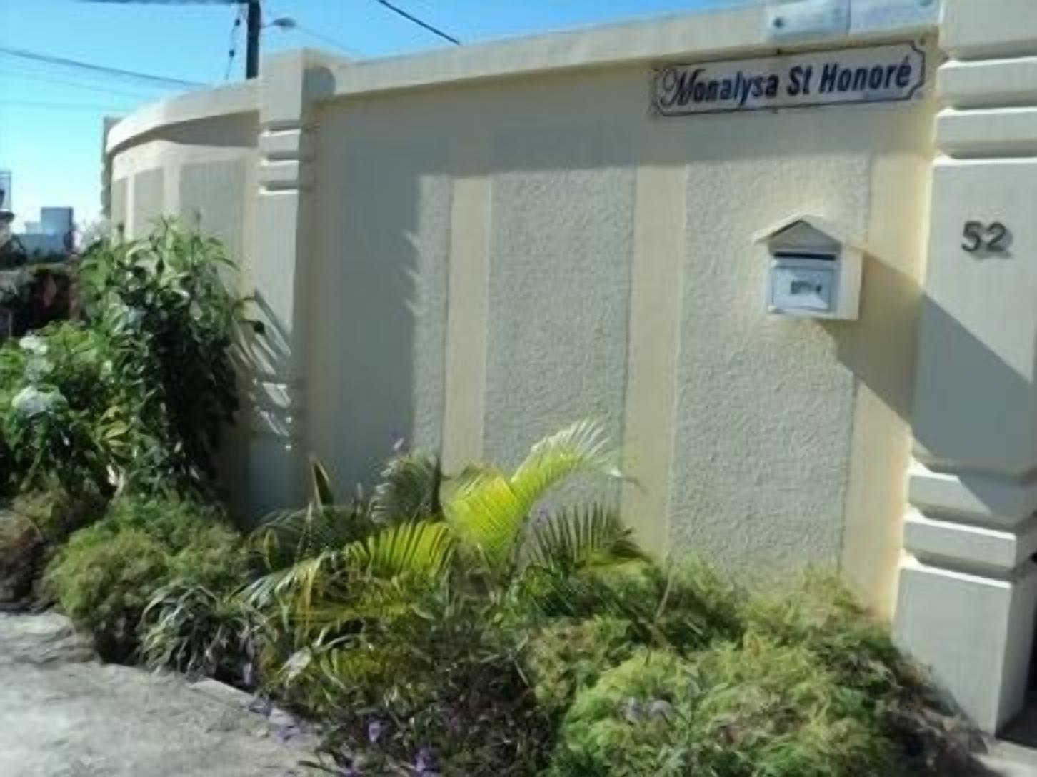 A building with a sign reading "Monalysa St Honore" and the number "52" on the wall.