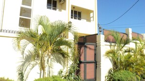 A multi-story building with balconies, air conditioning units, and a gated entrance. - Monalysa St Honoré Apartment & Studio (Grand-Baie)