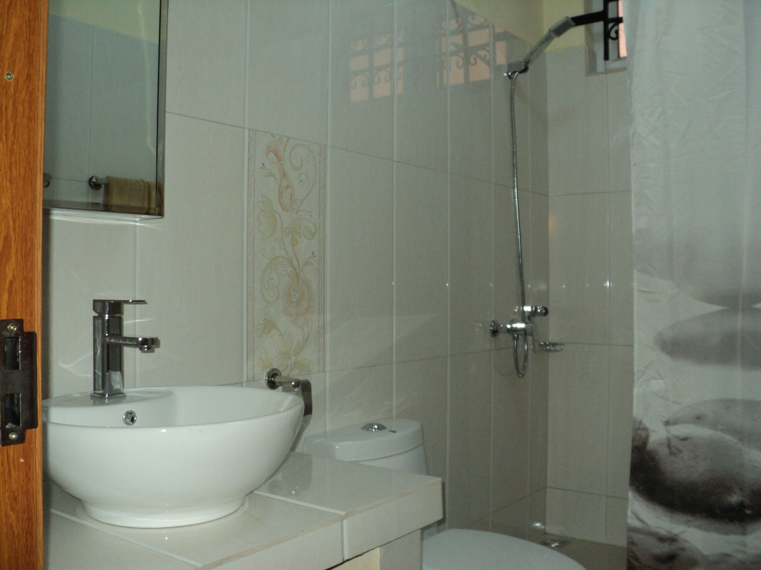 A bathroom with a white sink, toilet, and shower.