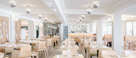 Un restaurant moderne avec des tables et des chaises disposées avec soin, un éclairage au plafond et un design épuré et minimaliste.