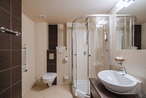 A modern bathroom with a glass-enclosed shower, a white sink, and a toilet. - Dwór Kombornia Folwark (Korczyna)