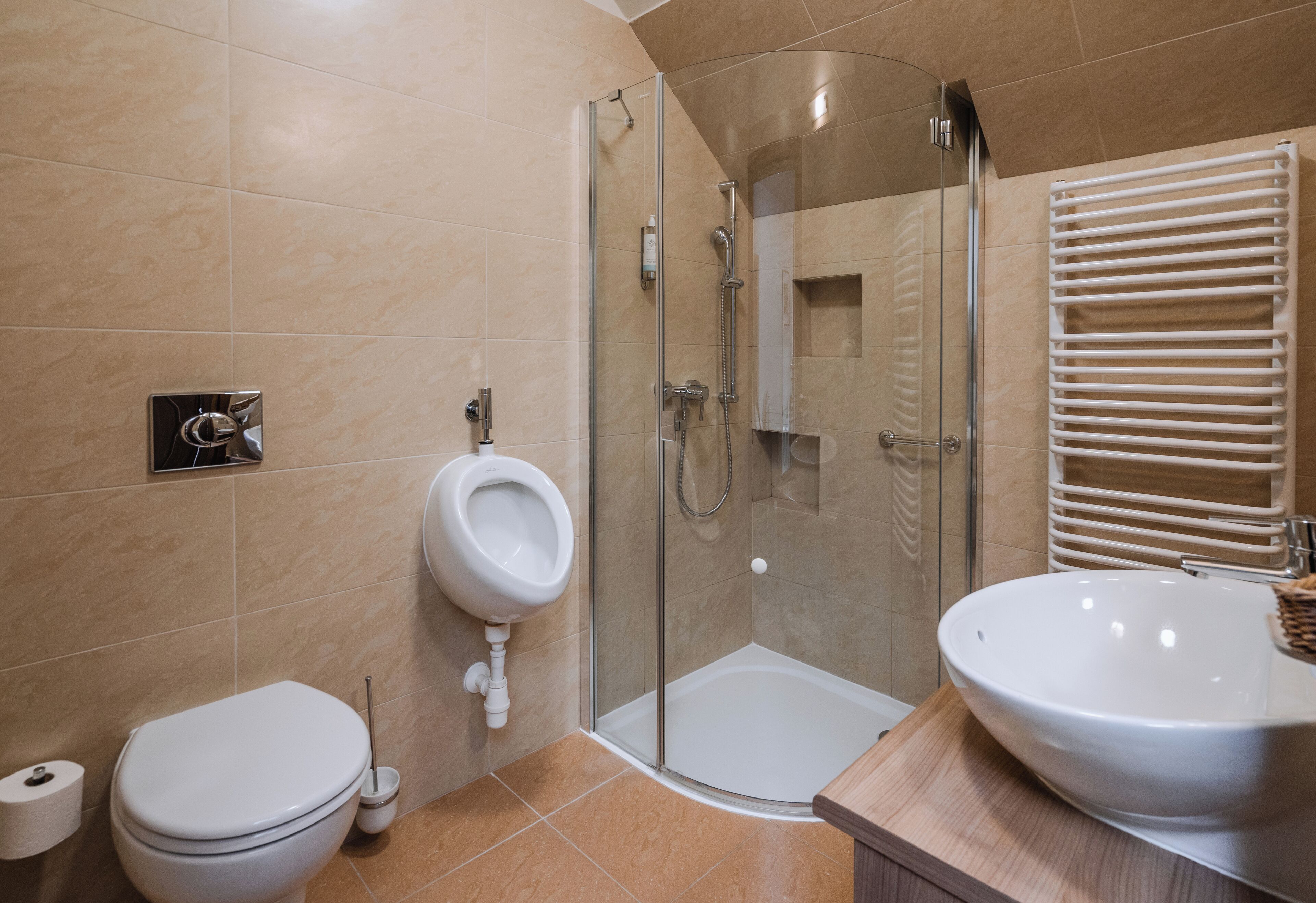 A modern bathroom with a toilet, a shower enclosure, and a sink.