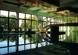 Una piscina techada, sillones reclinables de piscina