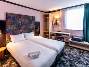 A hotel room with a bed, a desk, a chair, a wardrobe, and a window with curtains. - Ibis Styles Dijon Nord Valmy (Dijon)