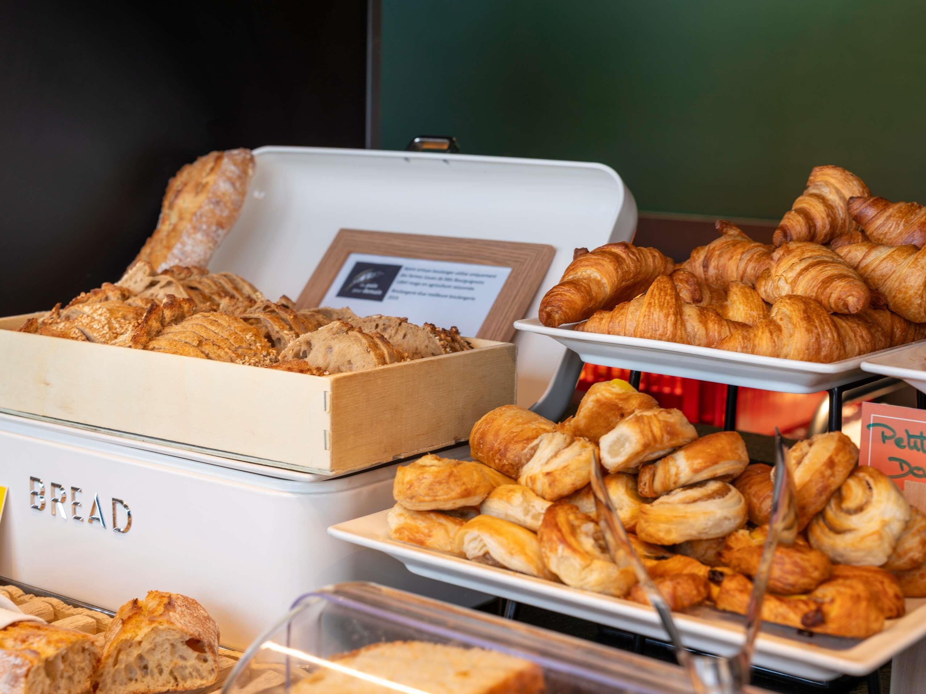 A buffet with various baked goods including bread and pastries.