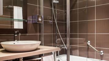 Un baño moderno con ducha envuelta en vidrio, un lavabo grande y una bañera.