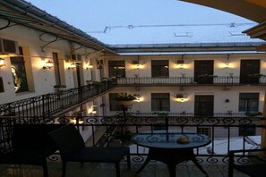 A courtyard with a balcony, outdoor seating, and a view of the building's facade. - Agape Hotel (Cluj-napoca)