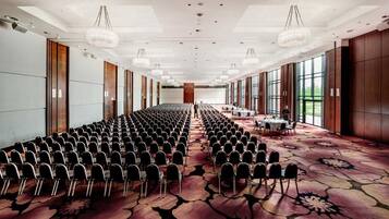 A conference room with rows of chairs, a long table, and large windows.