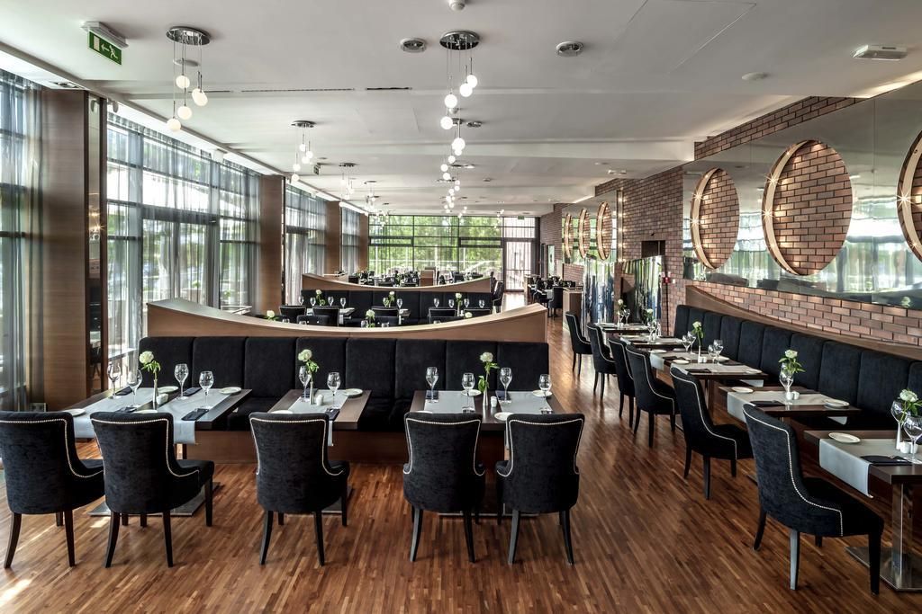 Un ristorante con un lungo bancone, cabine e tavoli.