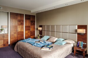 Ein Schlafzimmer mit einem großen Bett, einem Holzschrank, Nachttischen und einer Kopfteil.