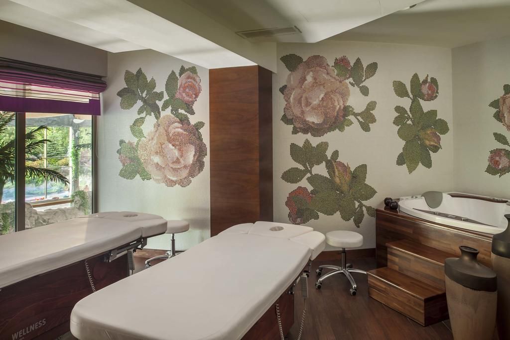 A wellness center with treatment tables, a massage chair, and a hot tub.