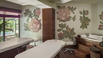 A wellness center with treatment tables, a massage chair, and a hot tub.