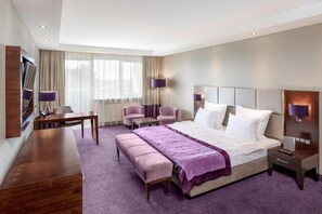 A modern hotel room with a large bed, a desk, a chair, and a bench. - Hotel Warszawianka (Serock)