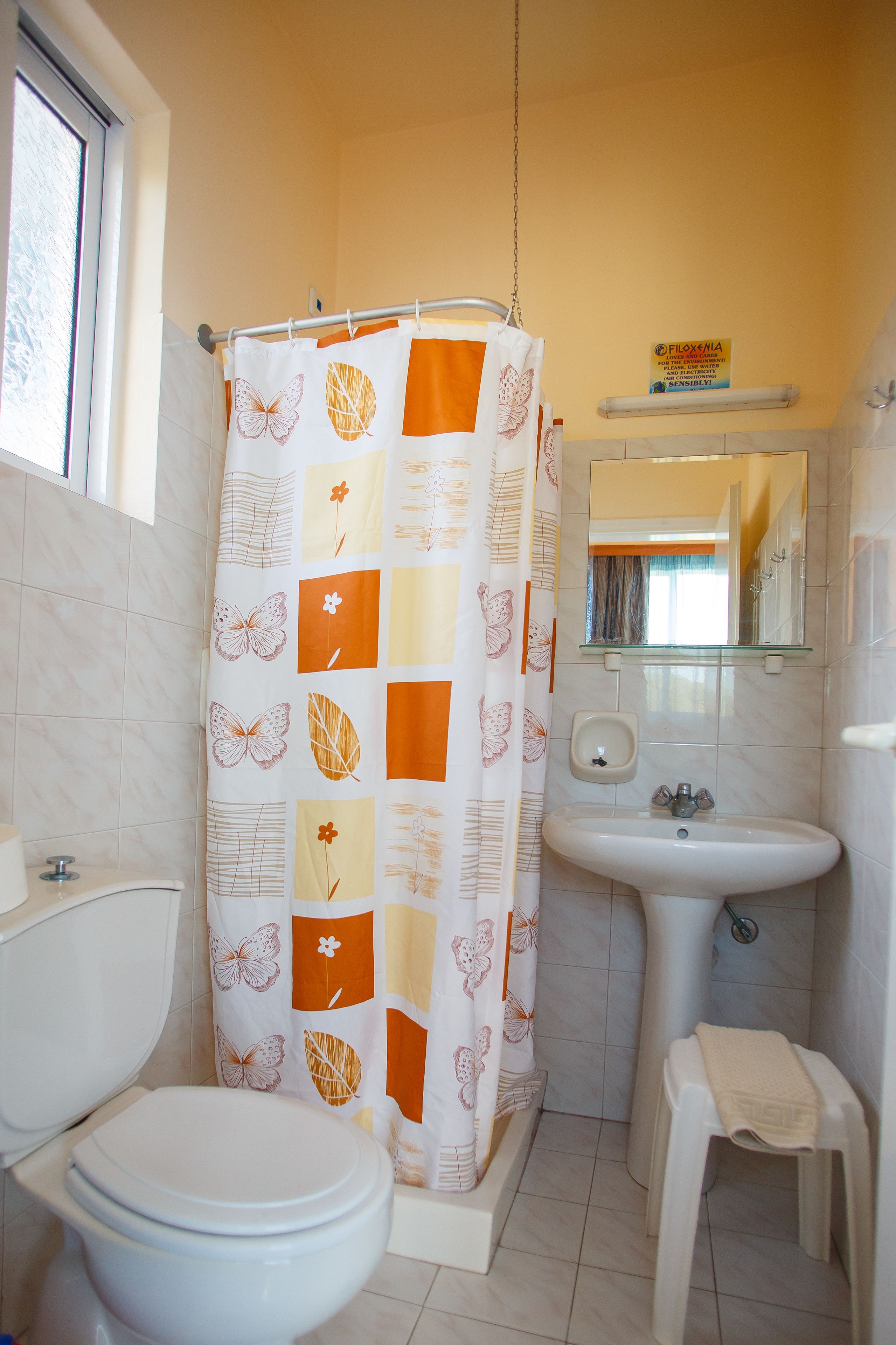 A bathroom with a toilet, sink, and shower curtain.