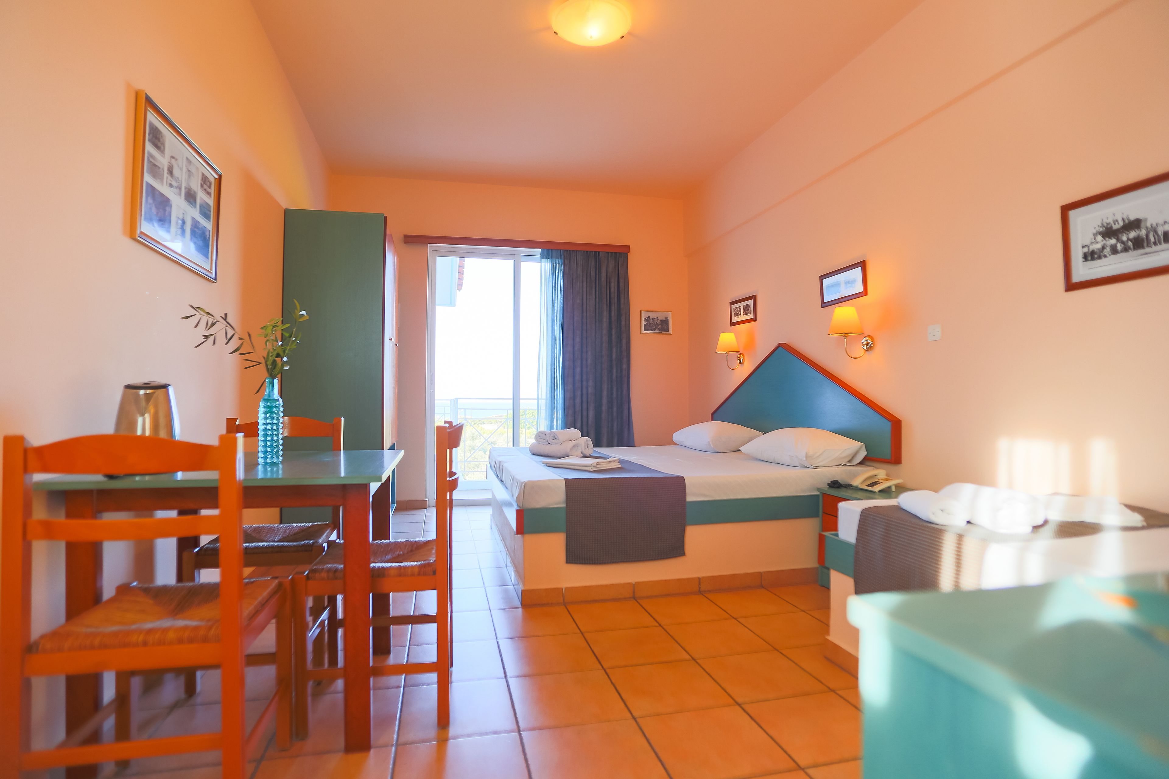 Una habitación de hotel con cama, escritorio, silla, mesa y ventana.