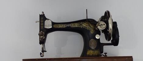 Una máquina de coser Singer sobre un atril de madera.