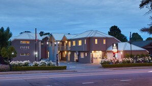 A hotel with a modern design, featuring multiple entry points and a well-lit exterior. - Fyffe On Riccarton (Christchurch)