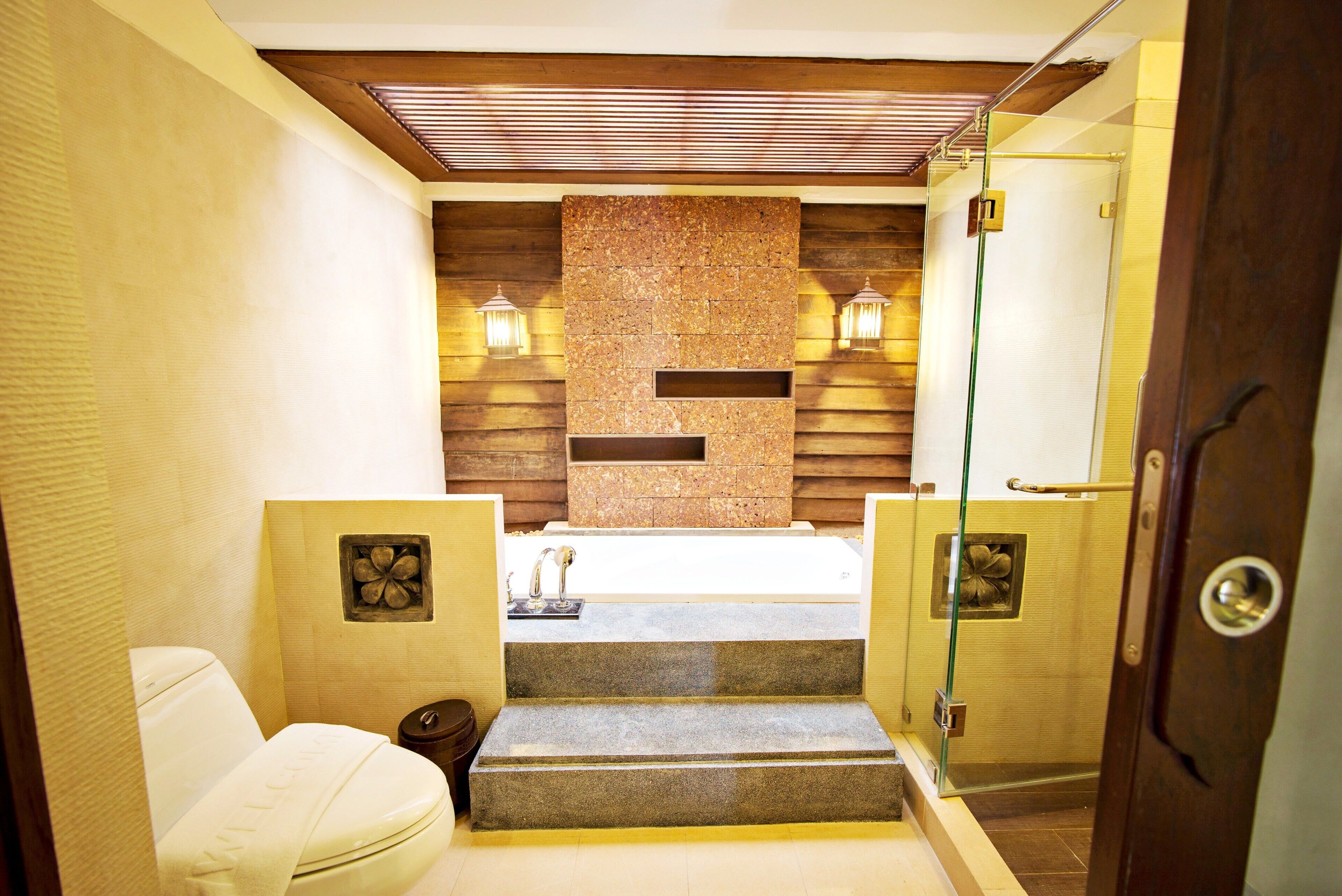 A bathroom with a bathtub, a toilet, and a shower area.