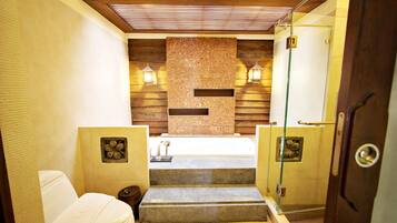 A bathroom with a bathtub, a toilet, and a shower area.