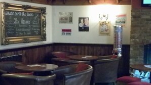A bar area with leather booths, a chalkboard menu, and various posters on the wall. - Dixie Arms (Nuneaton)