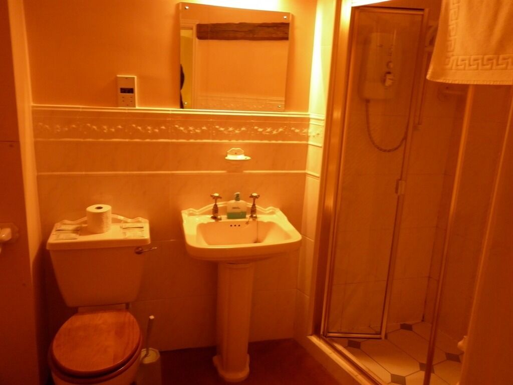 A bathroom with a toilet, sink, and shower.