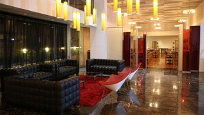 En moderne lobby med lædersofaer, et rødt tæppe og moderne lysarmaturer.